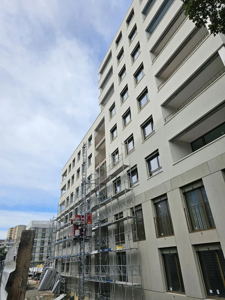 Isolation périphérique (ITE) en laine de roche sur un immeuble résidentiel neuf à Lausanne (VD), avec sécurité incendie renforcée, confort acoustique et crépi moderne.